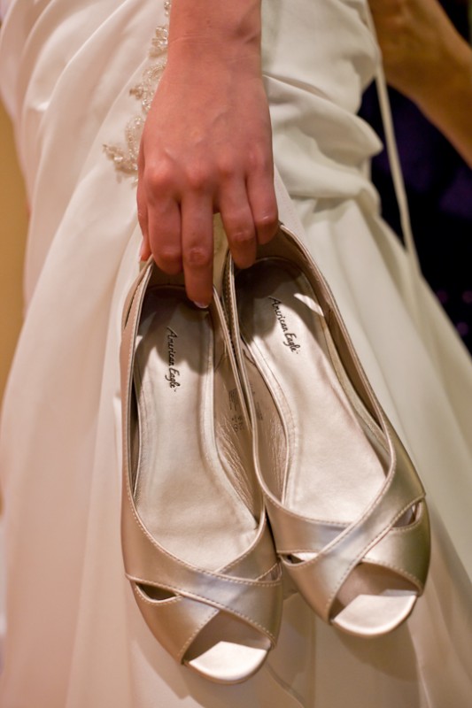 Photo of bride holding shoes