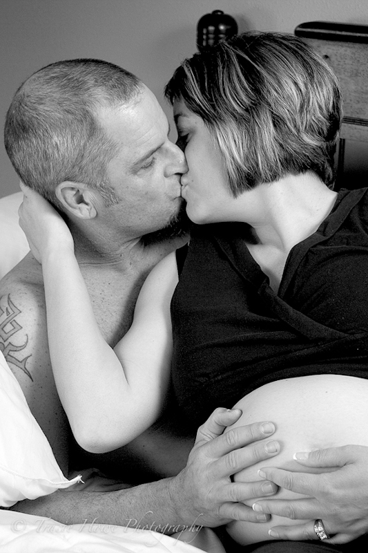 Portrait of pregnant woman kissing husband