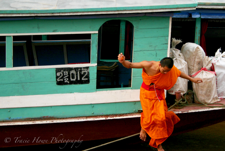 Photograph of monk jumping from boat in Laos