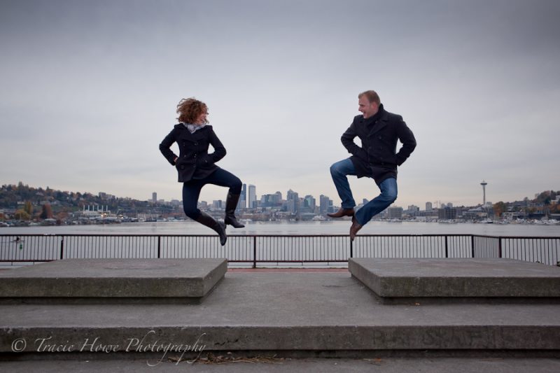 Engagement photo of couple jumping at Gasworks Park in Seattle