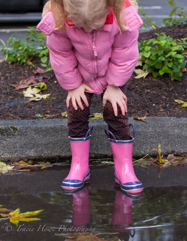 photo of girl looking into puddle