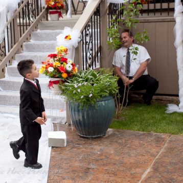 ring bearer playing hide and seek at wedding