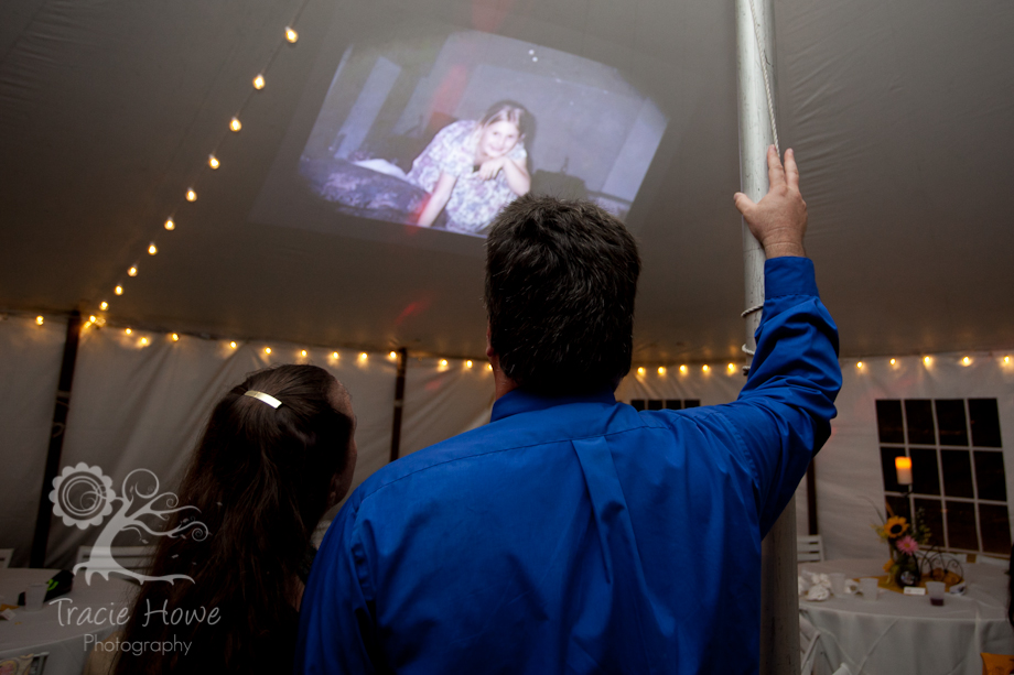 Couple viewing slideshow of bride and groom at wedding reception