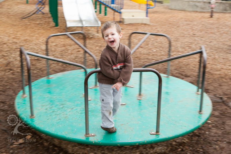 photo of boy spinning on merry-go-round