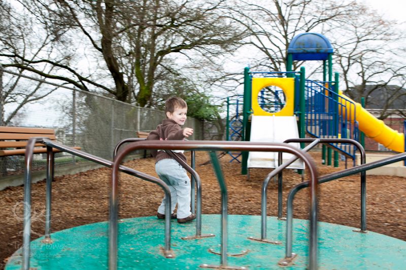 photo of boy spinning on merry-go-round