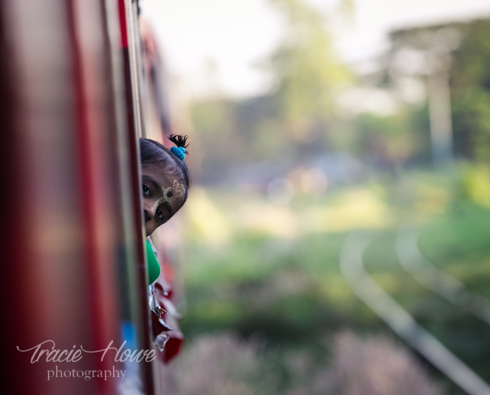 A shy little girl pokes her head out the window on Yangon's Circle Train.